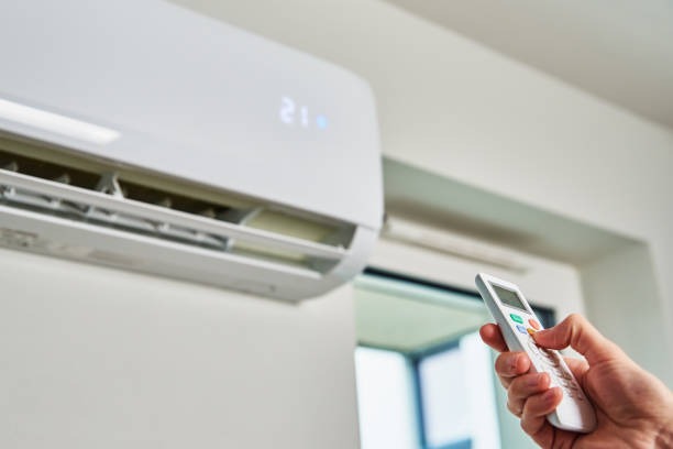 Controle remoto de ar-condicionado sobre uma superfície, ao alcance de mão